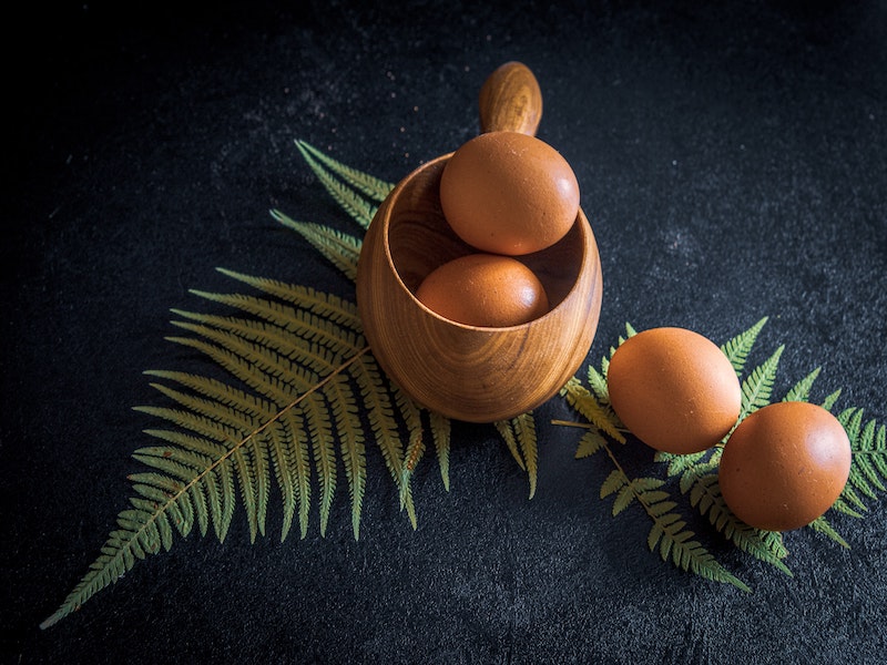 Organic brown eggs in a bowl and on the table.